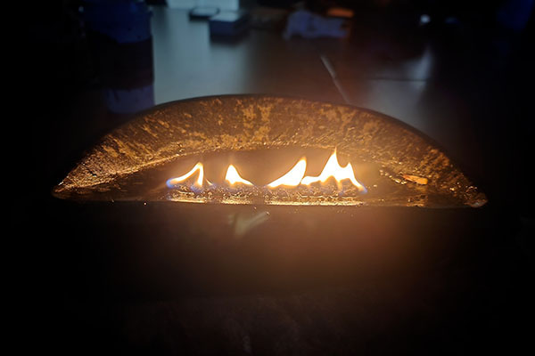 Flamme d'un qulliq dans une pièce sombre.